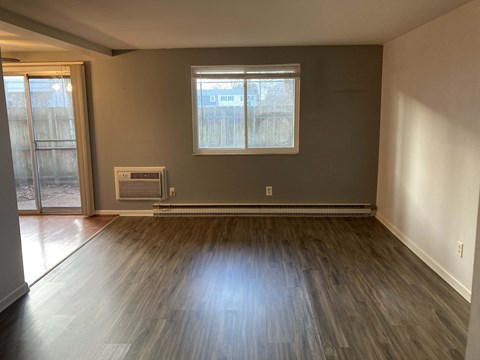 A room with a window and a radiator on the floor.