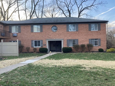 A red brick house with a black door and windows.