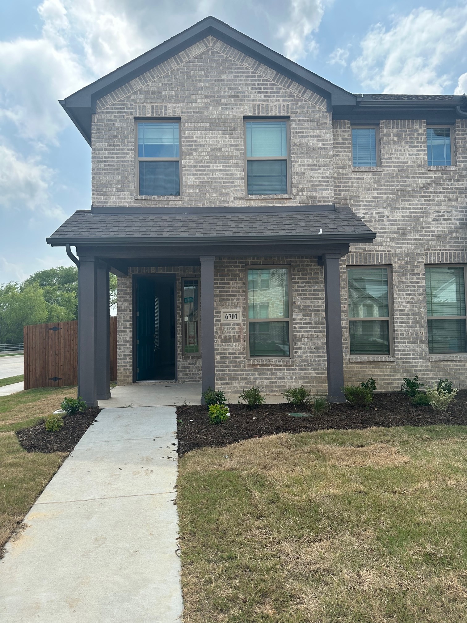 a brick house with a sidewalk in front of it