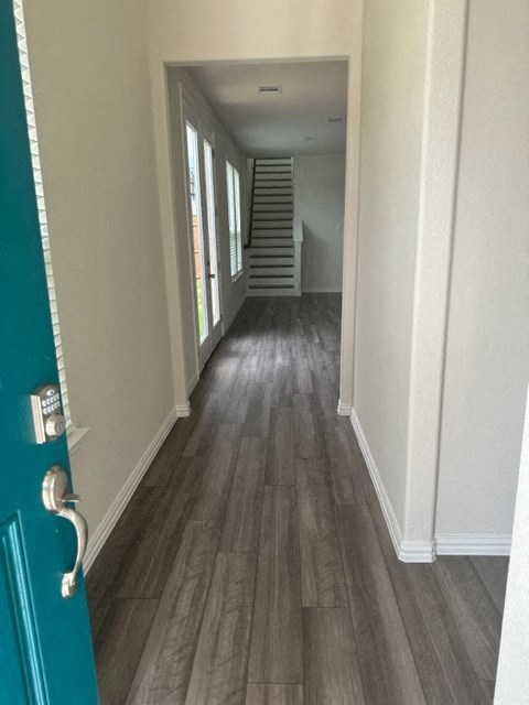 a hallway with stairs and a blue door
