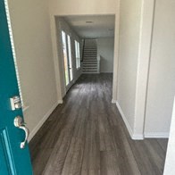 a hallway with wood floors and a blue door
