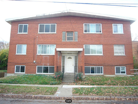 A red brick house with a white door and windows.
