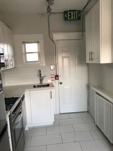 a small kitchen with a sink and a door