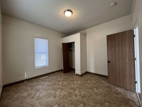an empty living room with a door and a window