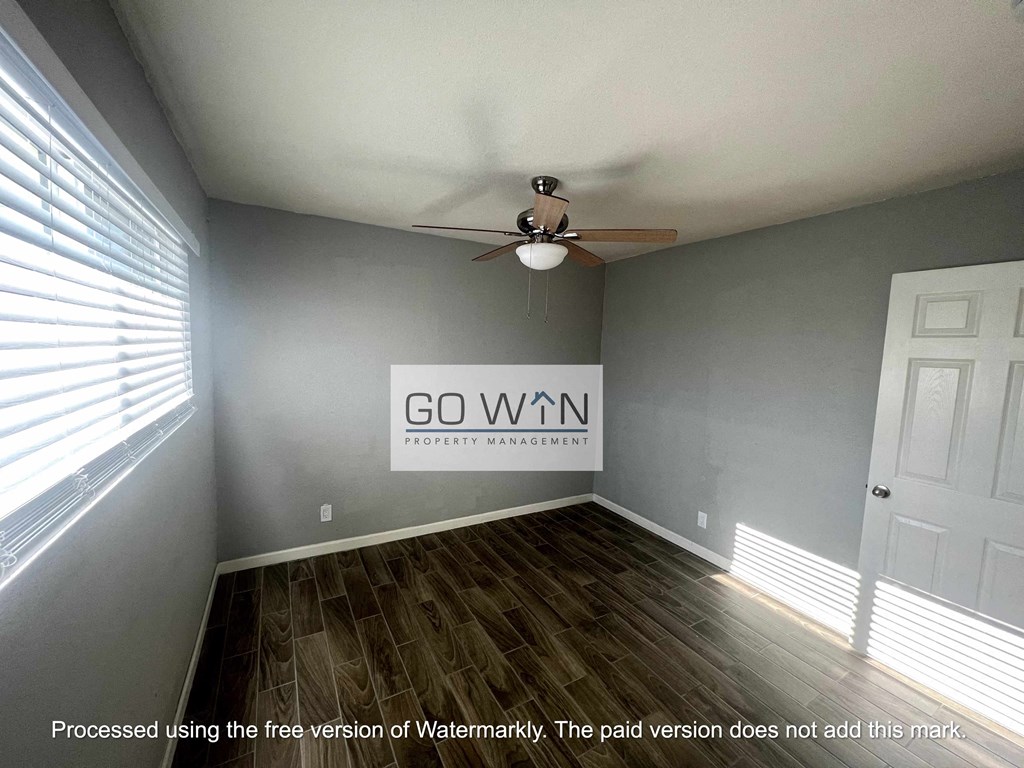 an empty room with a ceiling fan and a go win sign on the wall