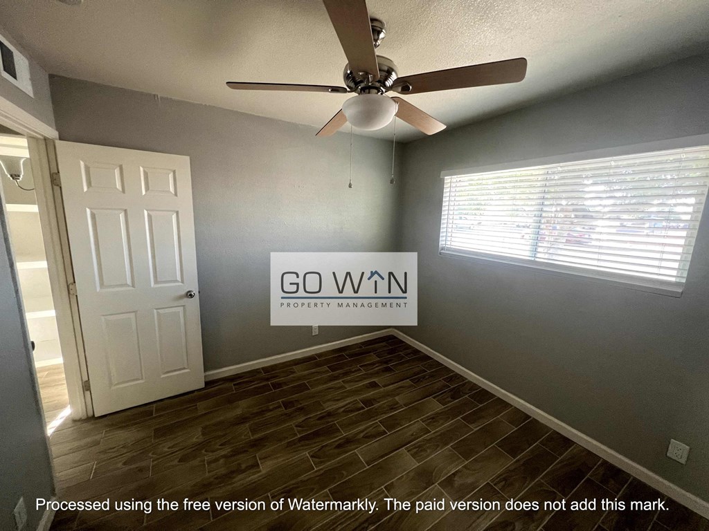 an empty living room with a ceiling fan  processed using the free version