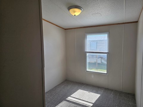 A room with a window and a view of a building outside.