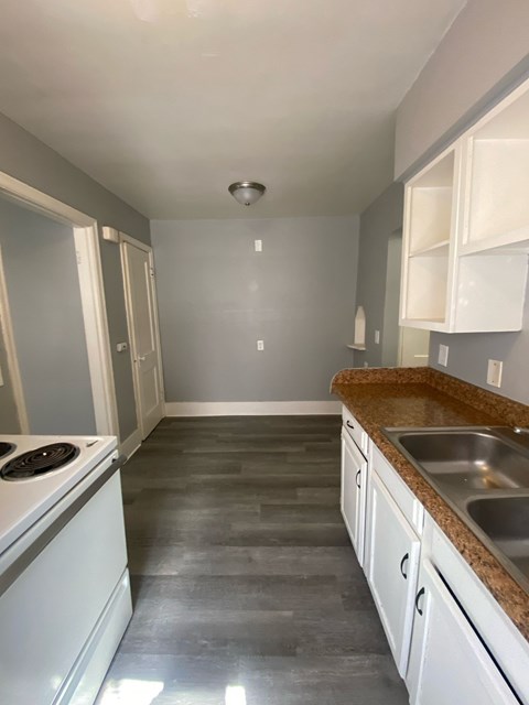 A kitchen with a stove top oven and a sink.
