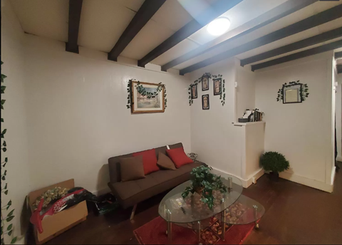 A living room with a brown couch and a glass table.