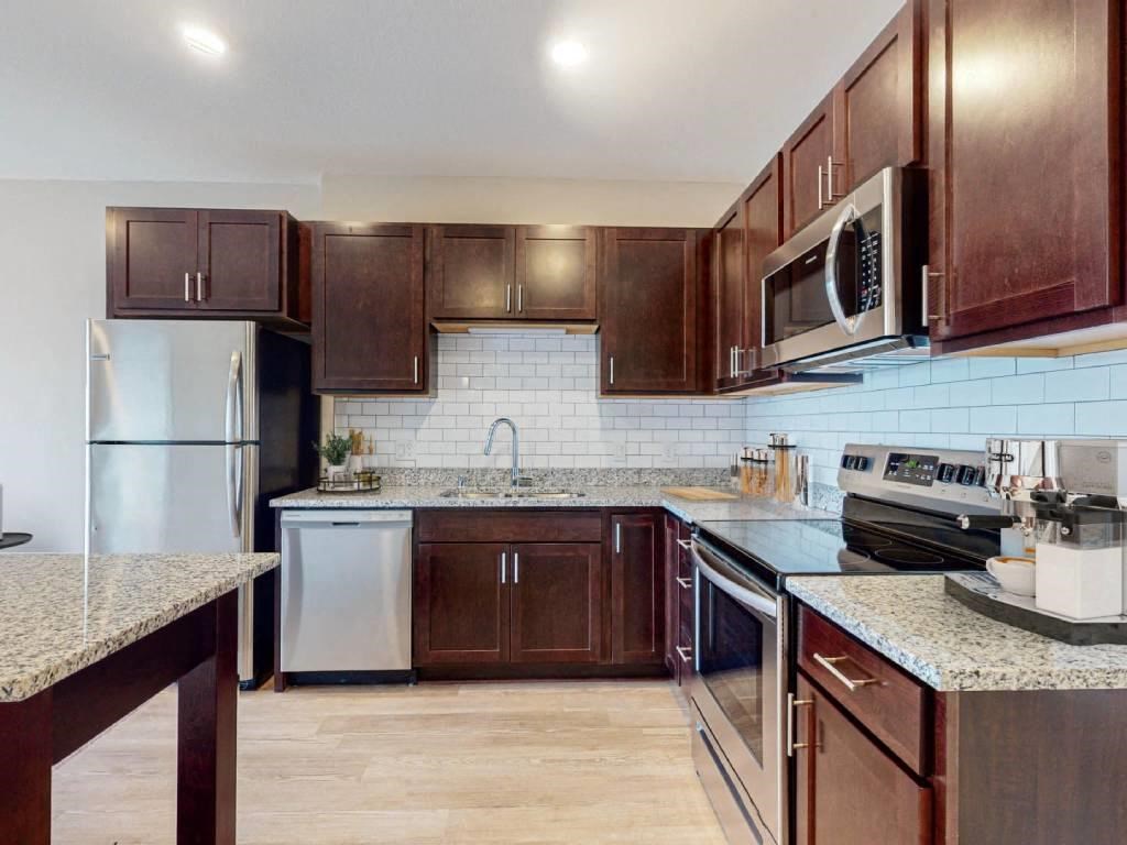 a kitchen with stainless steel appliances and wooden cabinets