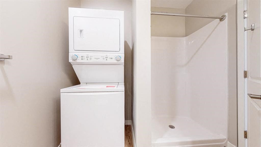 a bathroom with a washer and dryer and a shower