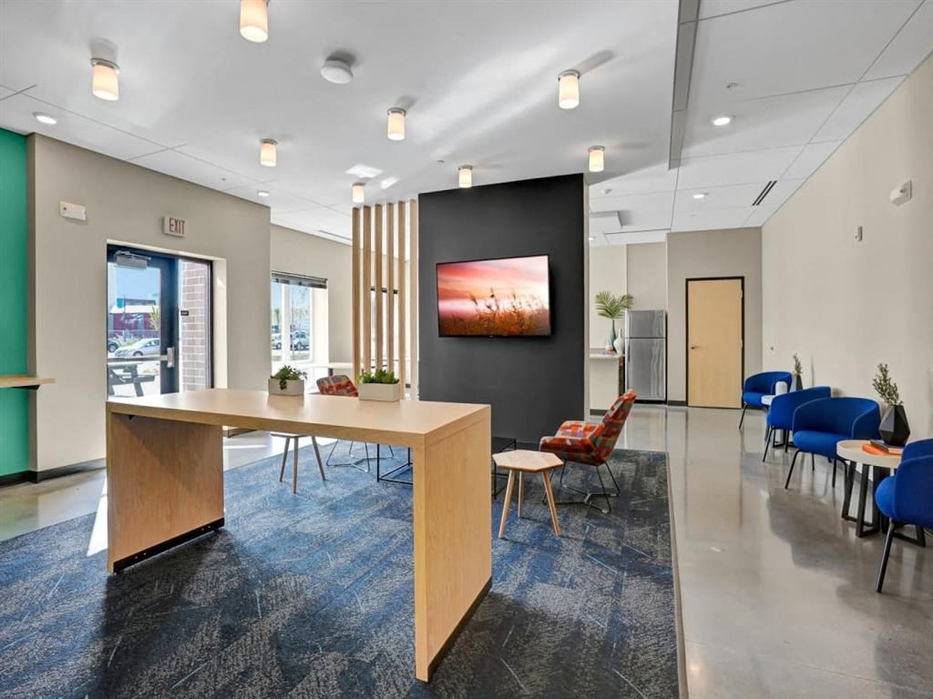 a conference room with a table and chairs and a tv in a lobby