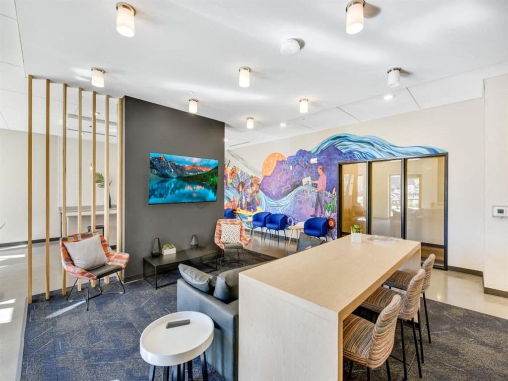 a living room with a bar and a mural on the wall