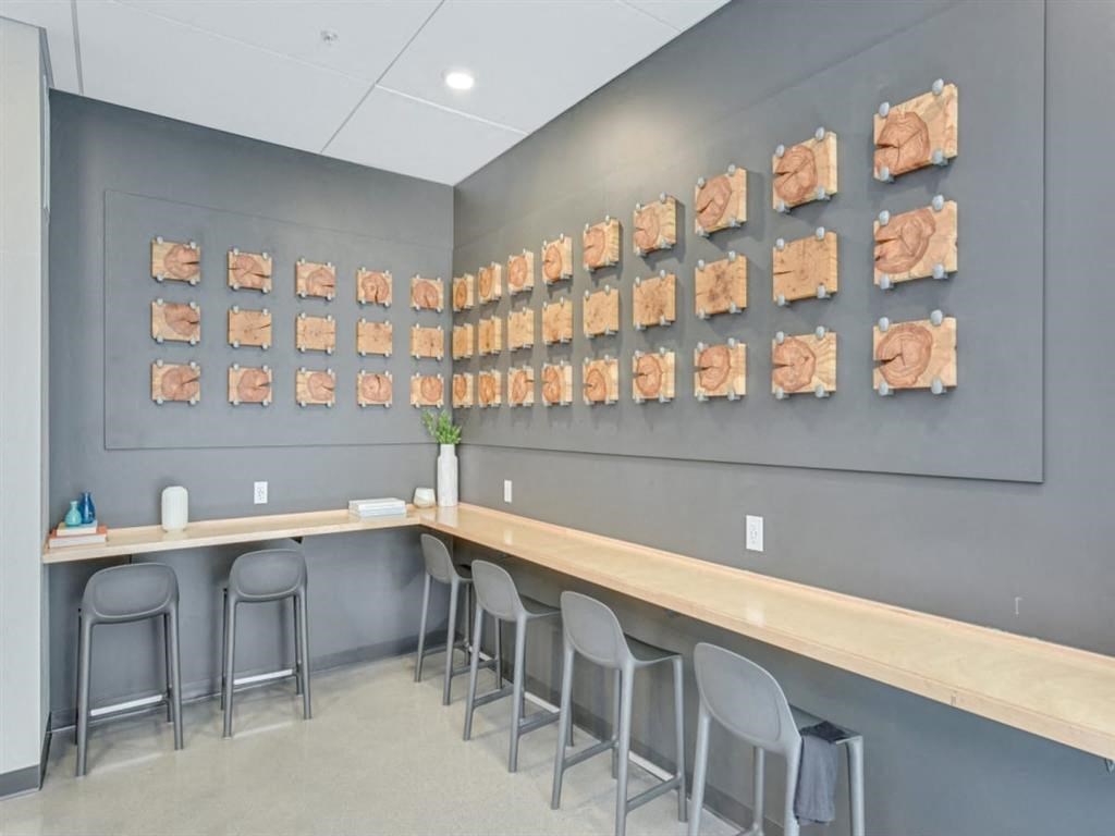 a long bar with stools in a room with art on the wall