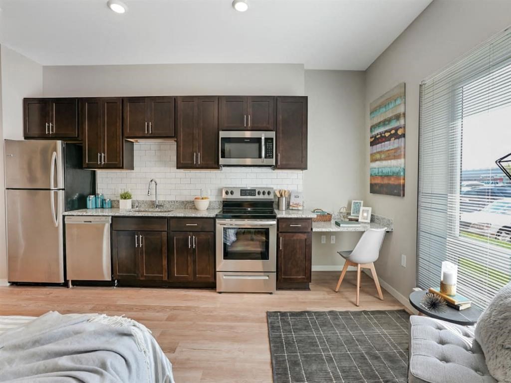 a kitchen with wooden cabinets and stainless steel appliances