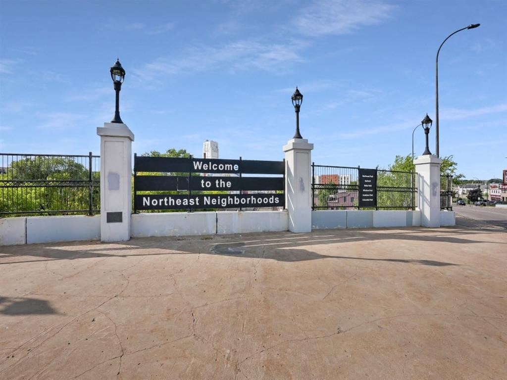 the welcome to the northeast neighborhood sign at the gate of a parking lot