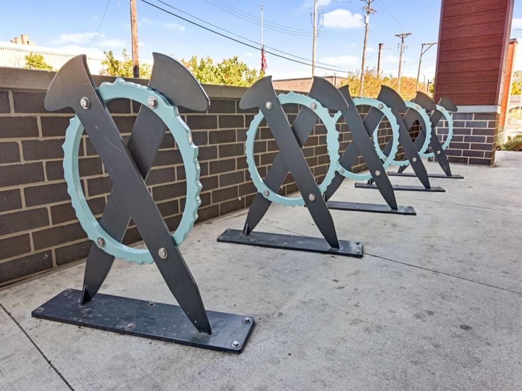 a row of metal horseshoes in front of a brick wall
