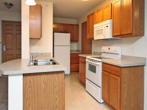 a kitchen with white appliances and wooden cabinets