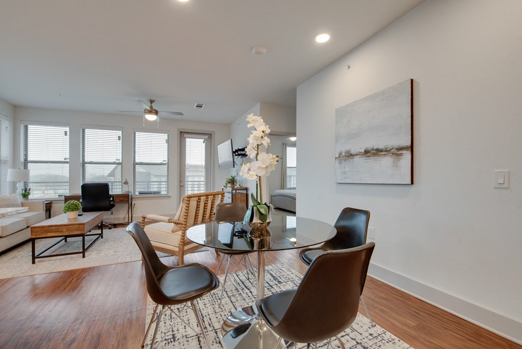 a living room with a glass table and chairs and a couch