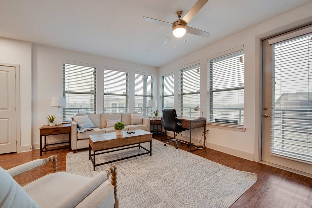 an open living room with a ceiling fan and windows