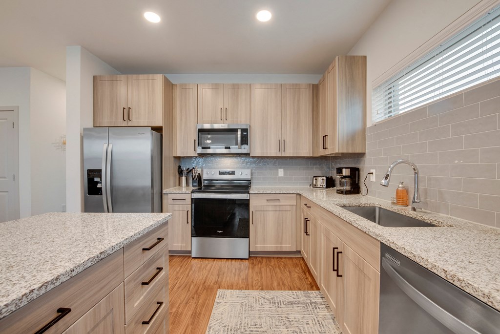 a kitchen with granite counter tops and stainless steel appliances