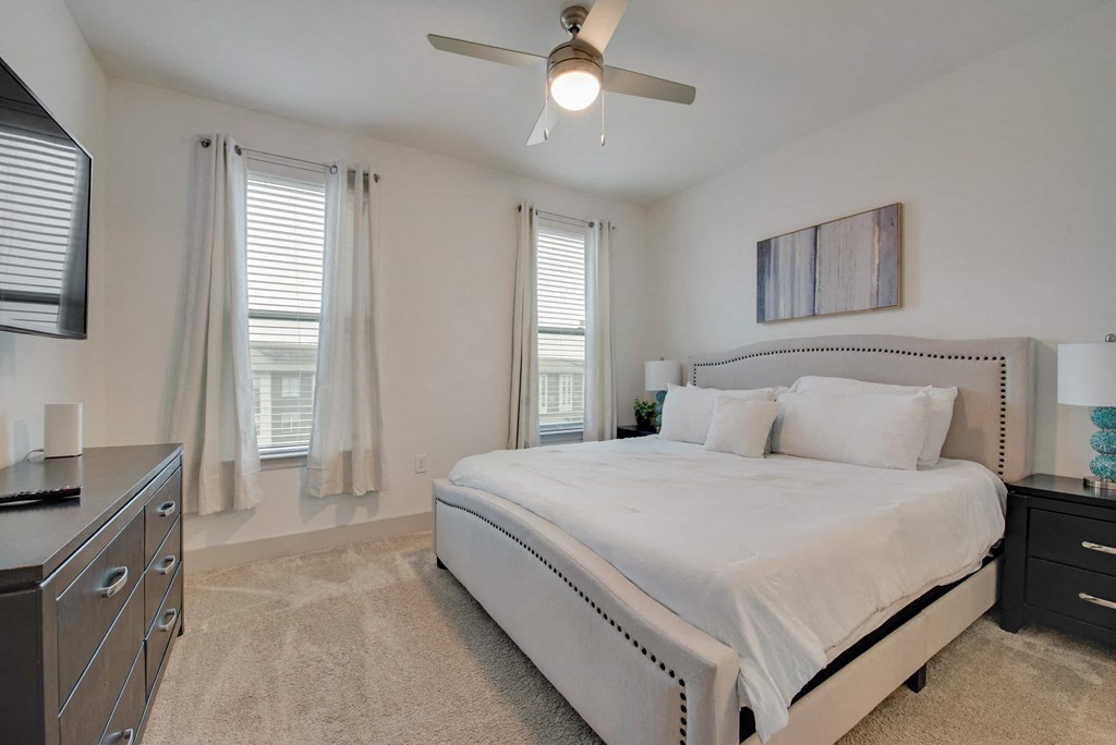 a bedroom with a large bed and a ceiling fan