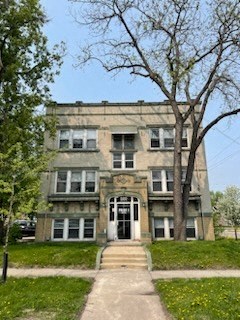 an old building with a tree in front of it