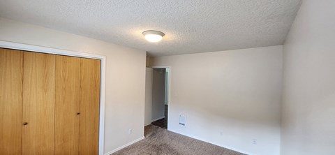 a bedroom with a closet and a door to a hallway