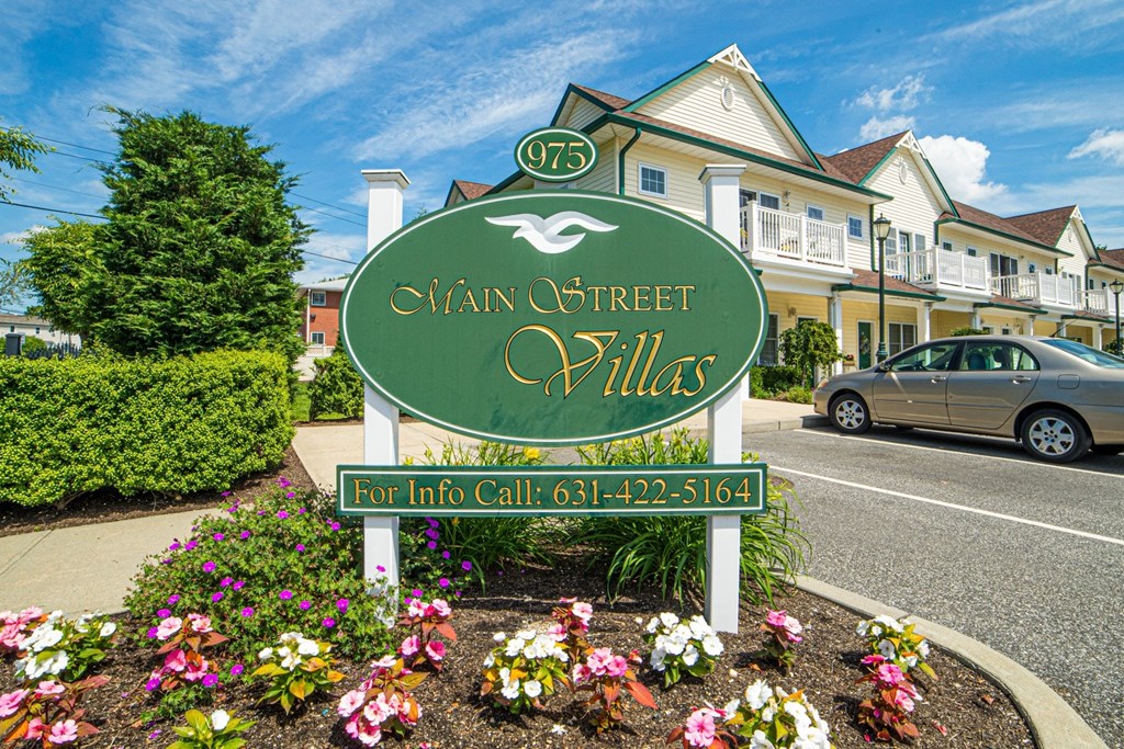 a street sign in front of a house on the side of a road