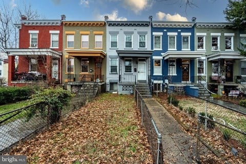 a row of colorful houses sitting in front of a yard