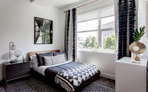 a bedroom with a bed and a large window