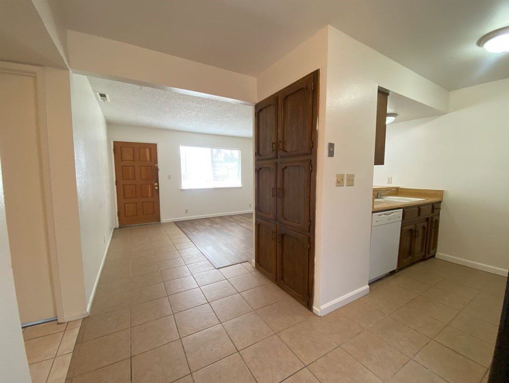 a kitchen and a living room with a sink and a door