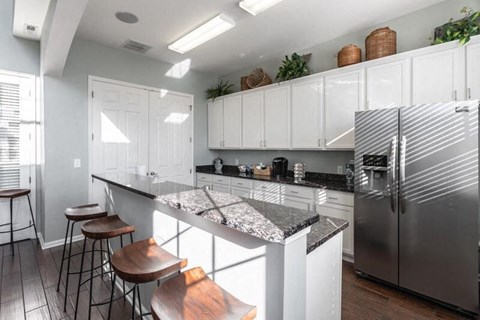a kitchen with marble counter tops and a stainless steel refrigerator