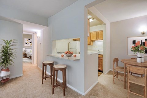 a living room and kitchen with a table and stools