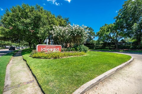 a park with a red and white sign in the grass
