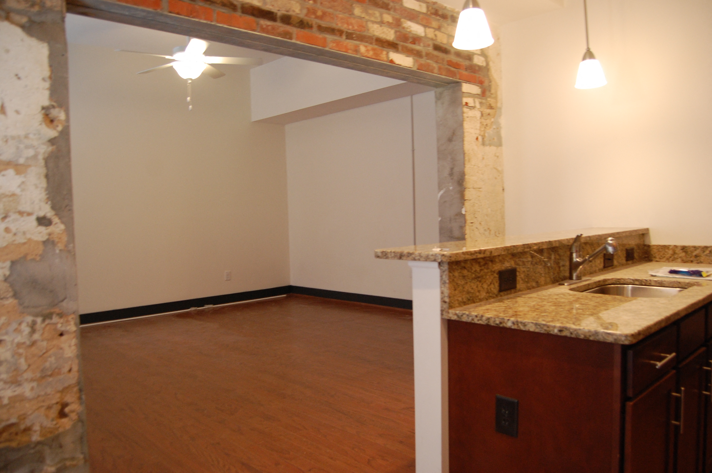 an empty living room with a sink and a mirror