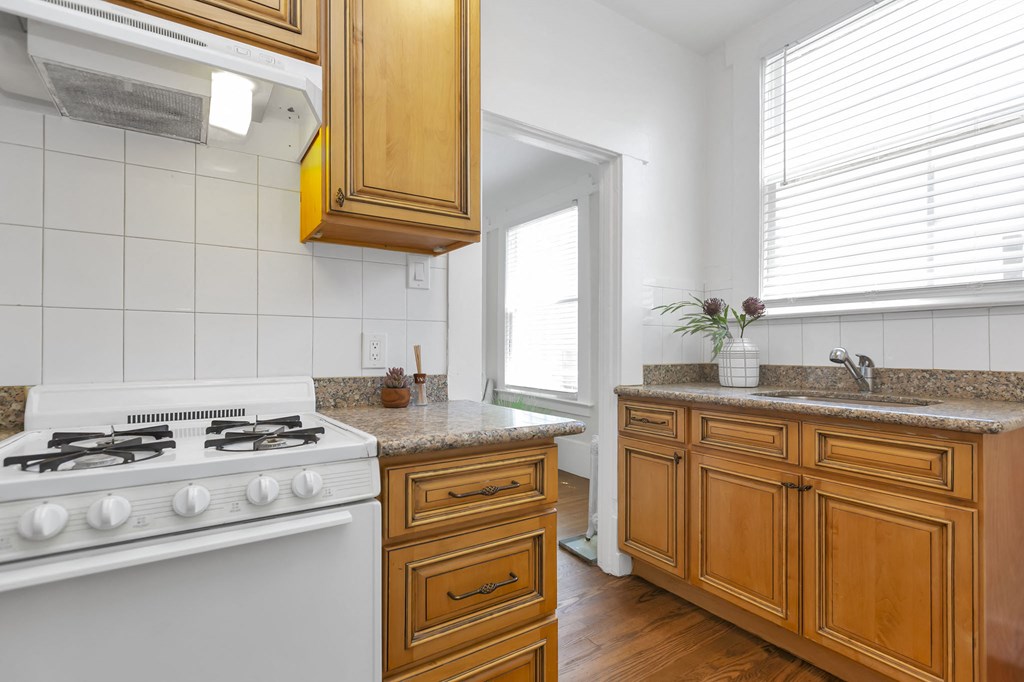 a kitchen with wooden cabinets and a white stove