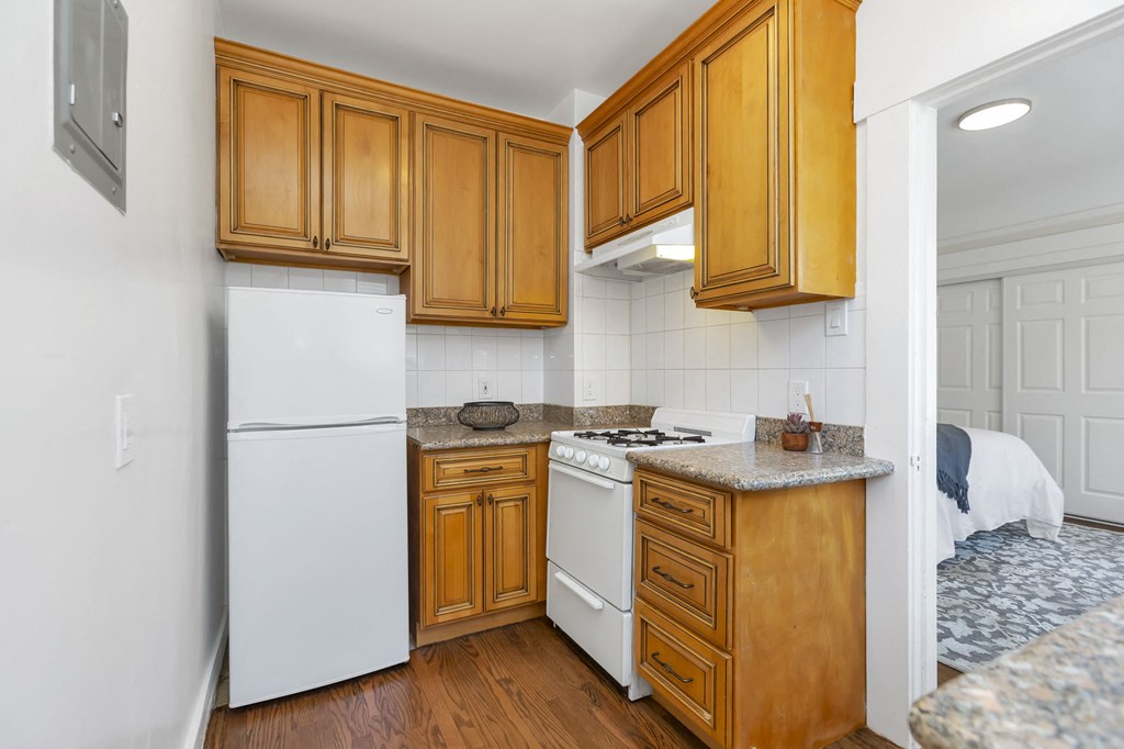 a kitchen with white appliances and wooden cabinets