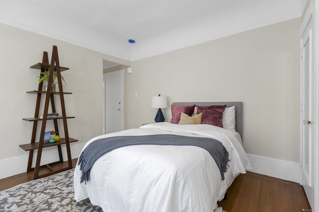 a bedroom with a bed and a ladder in the corner