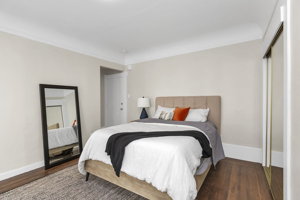 a bedroom with a large bed and a mirror