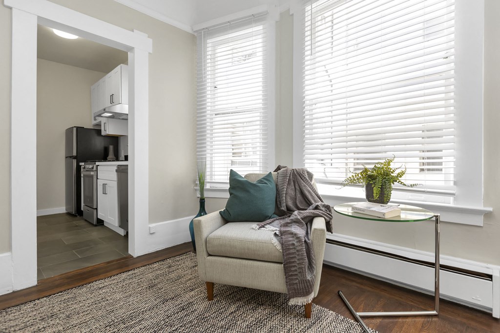 a living room with a couch and a chair and a kitchen