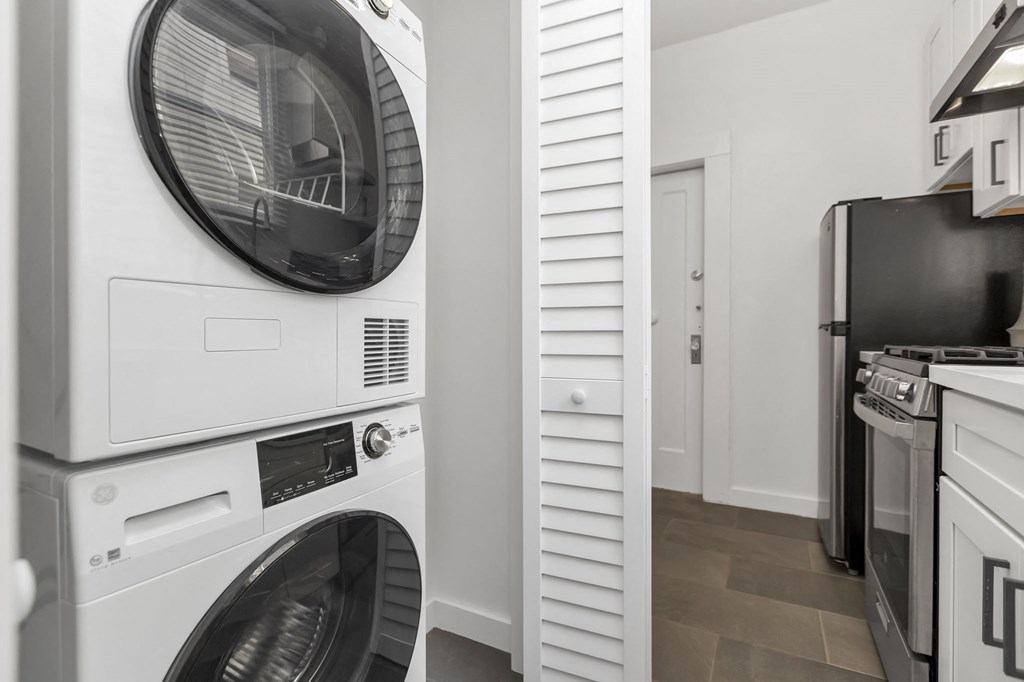 a washer and dryer in a laundry room with a refrigerator