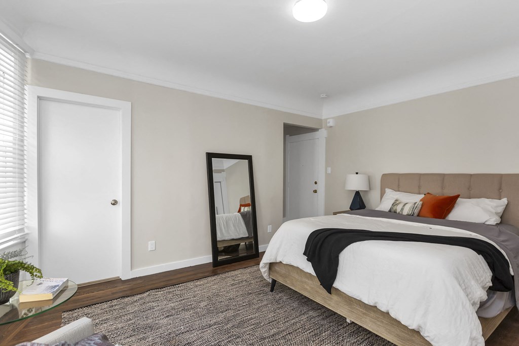 a bedroom with a large bed and a mirror