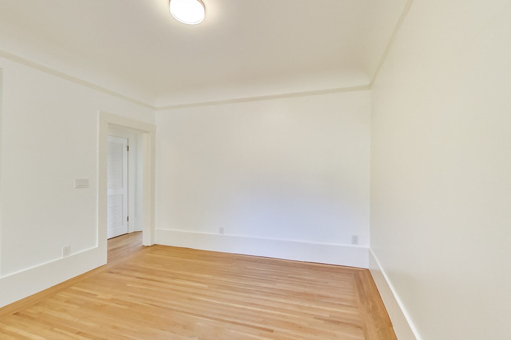 a living room with wood floors and white walls