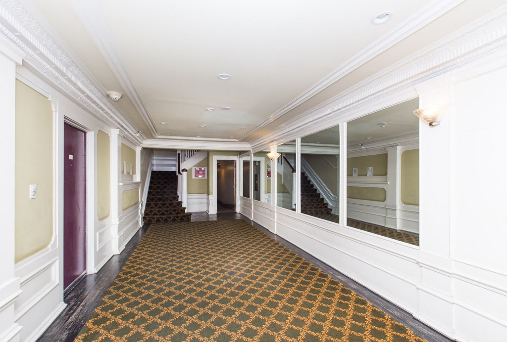 a large hallway with windows and a carpeted floor