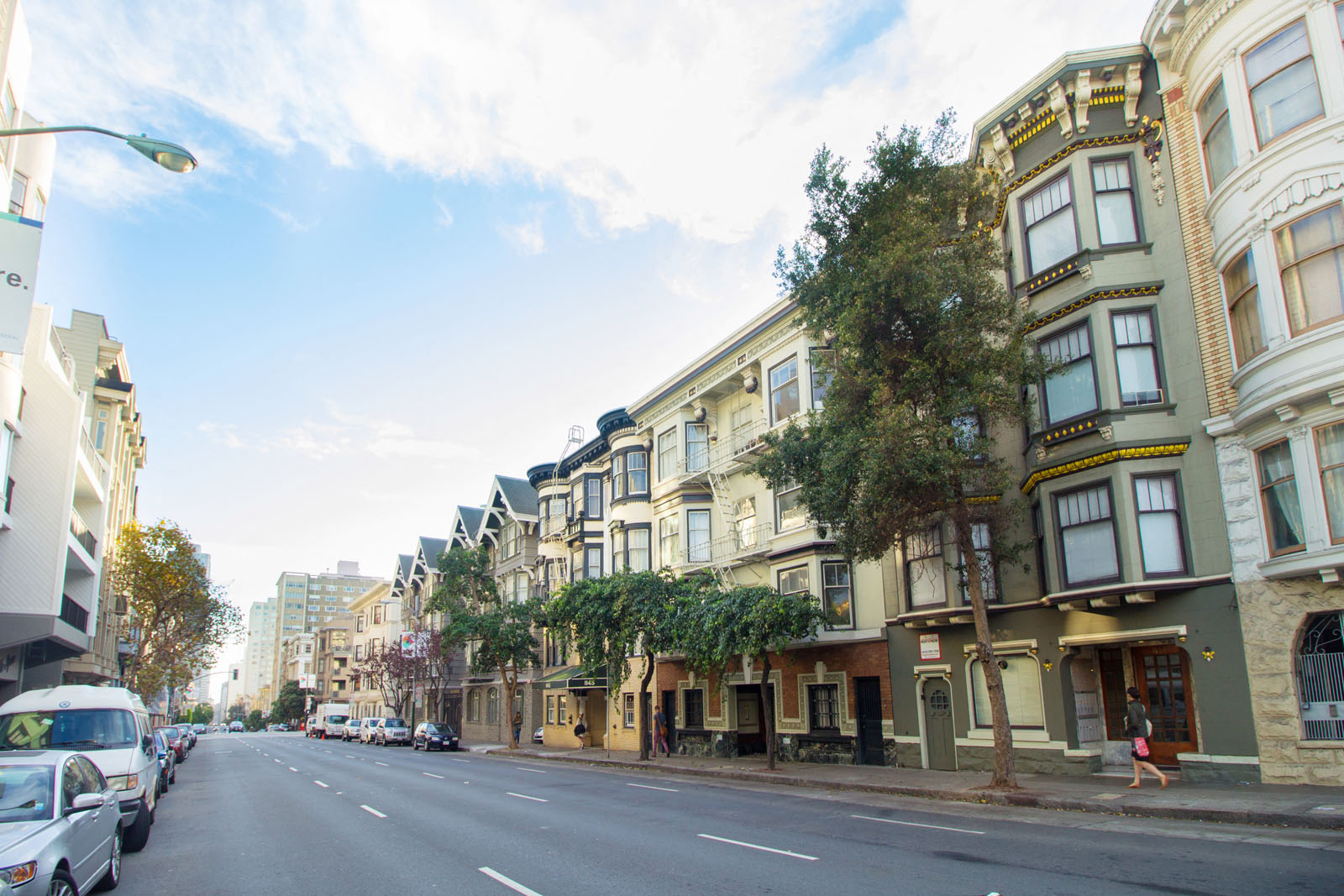 a city street with cars parked on the side of a row of buildings