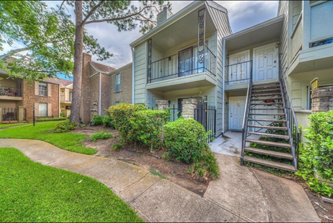 a view of an apartment building with stairs and a sidewalk