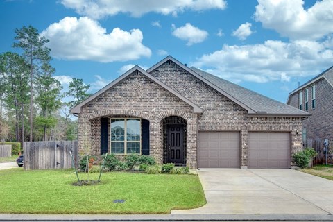 a brick house with a driveway and a garage door