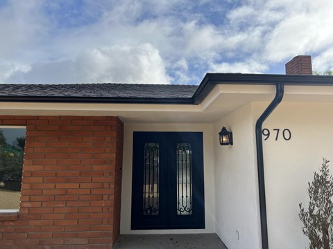 A house with a black door and a number 970 on the wall.
