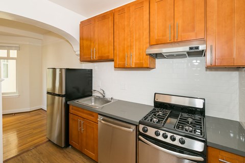 A kitchen with wooden cabinets and a black stove top oven.